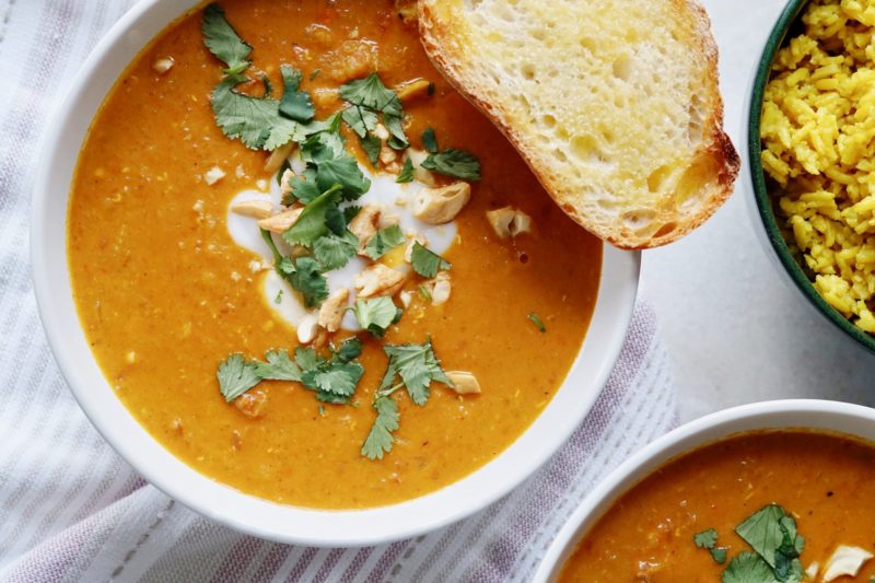 Bowl of coconut curry chicken soup with turmeric rice.