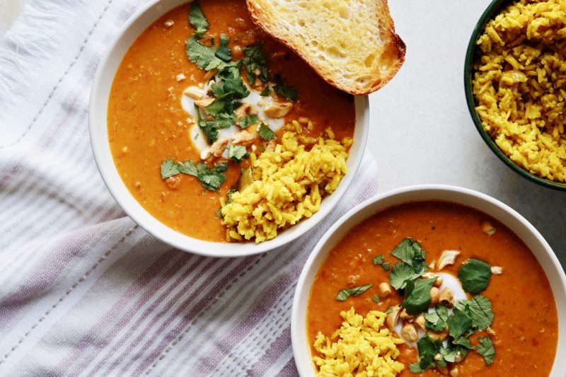 Bowl of coconut curry chicken soup with turmeric rice.